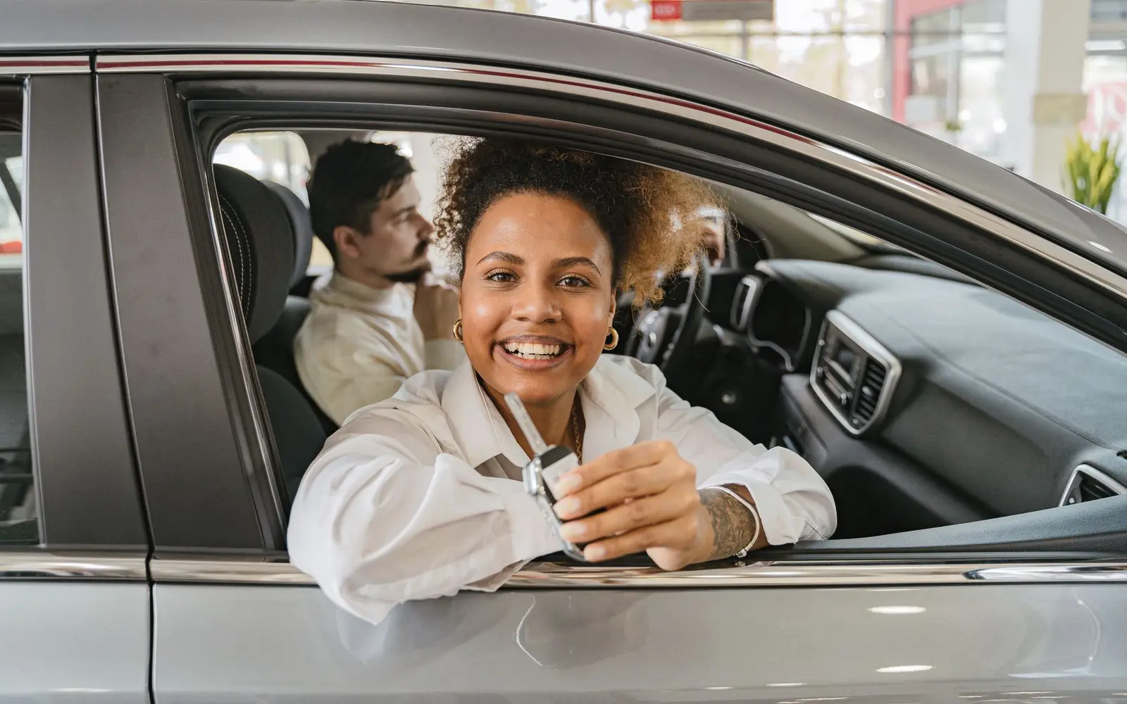 A driver holding the keys to a car she has just bought