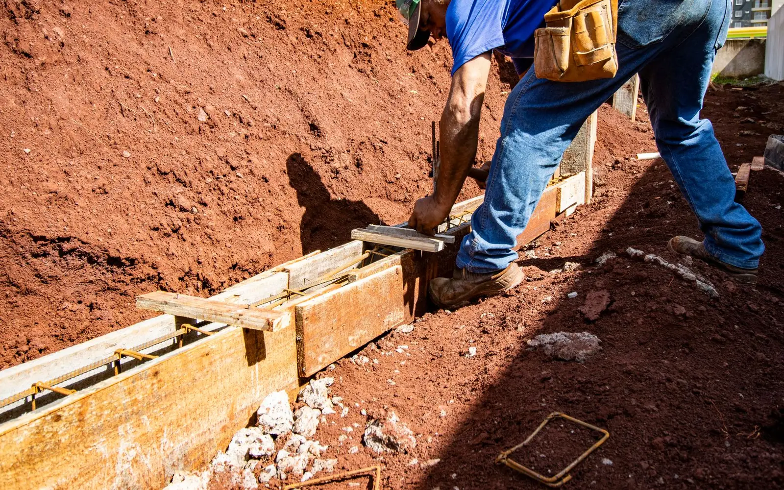 A construction worker laying a foundation on an outdoor building site